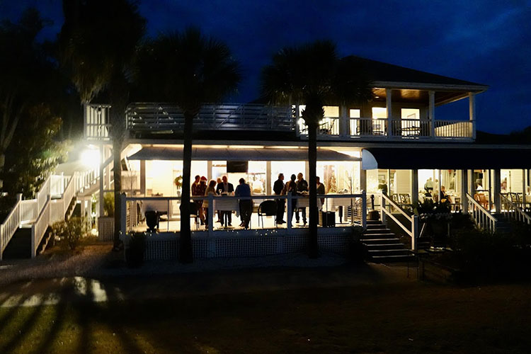 guests socializing on the patio area of the clubhouse in the evening